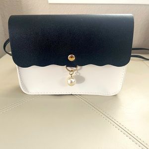 Black and White Small Crossbody With Faux Pearl closure.